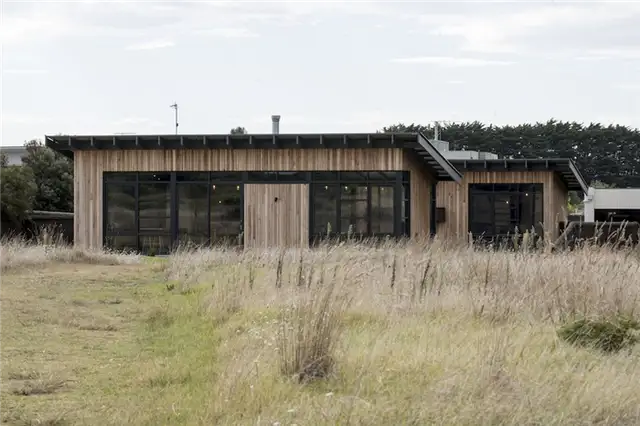 Дом Golf Course House с черными оконными наличниками и соответствующей крышей