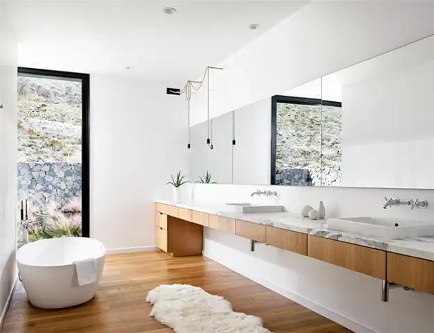 Дизайн белой ванной комнаты с деревянным полом и зеркалом во всю стену