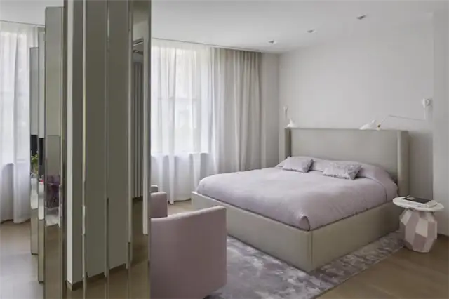 Hampstead House от TG-Studio - мансардная спальня со встроенными системами хранения и креслами у окна