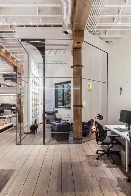 В офисе Nong Studio есть стеклянные перегородки и массивные деревянные колонны