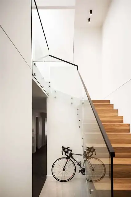 В доме Upside Down House деревянная лестница с изящными стеклянными перилами