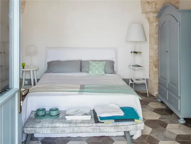Декор спальни в пляжном стиле с напольной лампой и полками