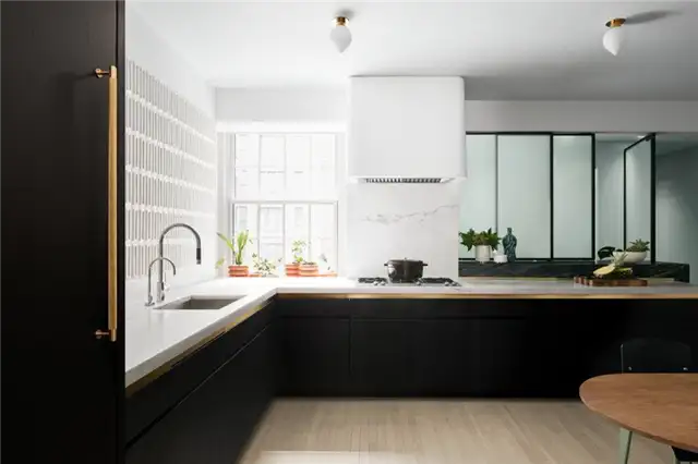 Laura and Jason Schwalbe Apartment Redesign by MKCA - современные черные кухонные шкафы с латунными акцентами и белым декором