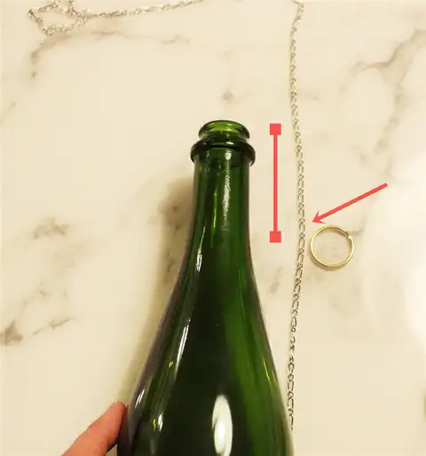 Выньте кольцо для ключей из бутылки.