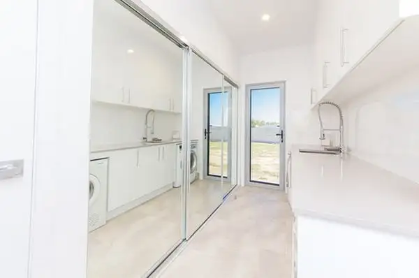 white-laundry-room-with-mirrored-closet-doors