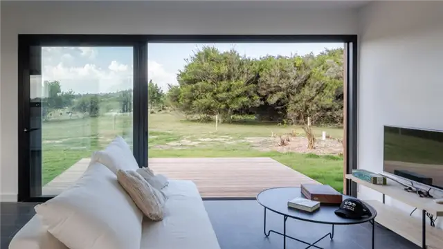 Белый диван с телевизором в доме Luanda House by Fábrica de casas