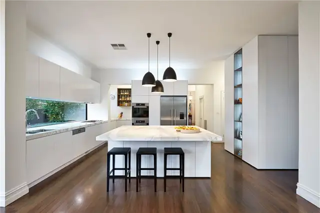 Современная кухня с белыми шкафами в резиденции East Malvern от LSA Architects