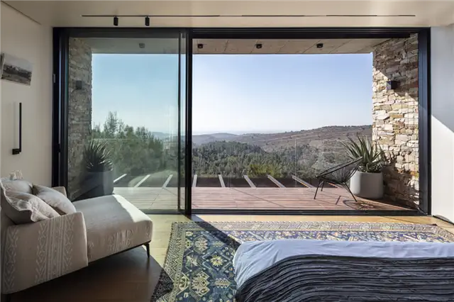 Современная вилла с каменной облицовкой от Dana Oberson Architects - вид на спальню