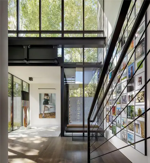 Современный индустриальный дом Stirrup House от Olson Kundig - лестничная стена с произведениями искусства